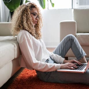 Studentin sitzt mit Laptop auf dem Boden - Generation Z im Studium