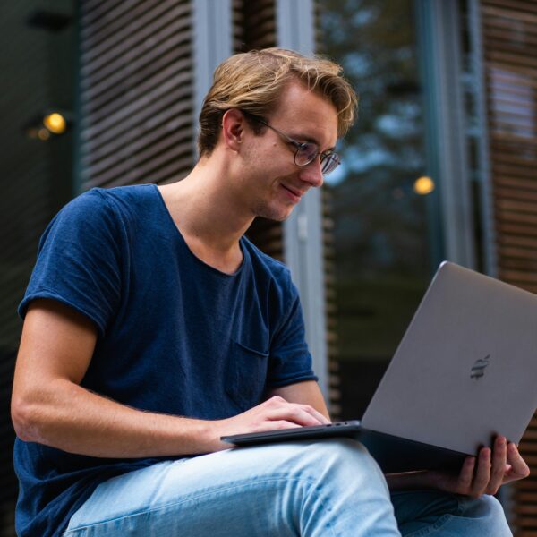 Mann sitzt und schaut in einen Laptop